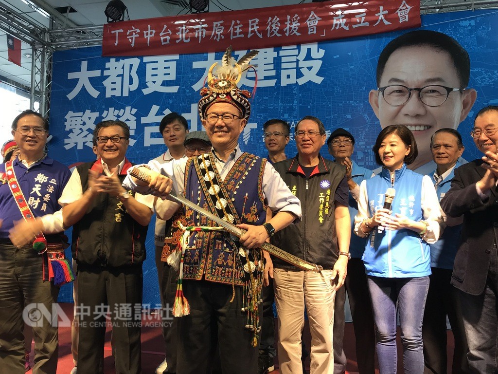 國民黨台北市長參選人丁守中(中)13日出席原住民後援會成立大會,會中提出多項提升原住民權益的相關政策,並穿上排灣族勇士服飾,盼選舉時可過關斬將入主台北市政府。中央社記者劉建邦攝 107月10月13日