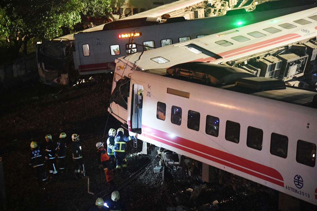 台鐵6432次普悠瑪列車21日下午在宜蘭新馬車站發生出軌翻覆事故,造成重大傷亡,各節車廂因擠壓而曲折變形,警消到場救援,在各車廂間仔細搜索,不放過任何角落。 中央社記者孫仲達攝 107年10月21日