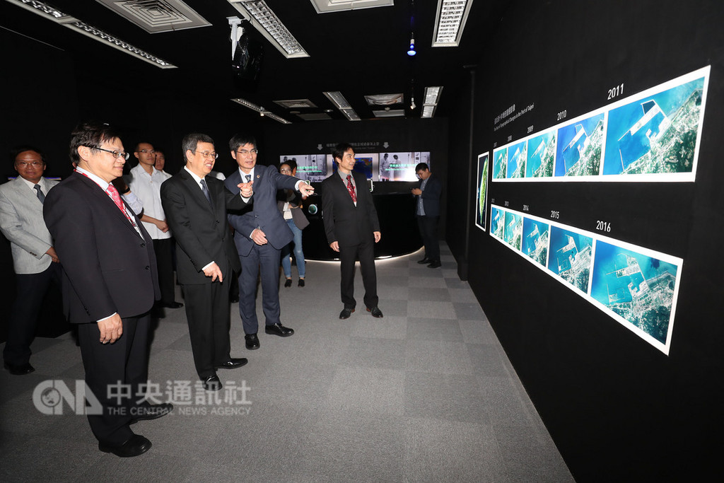 副總統陳建仁(前左2)22日在總統府特展室出席「福衛系列衛星特展」,觀看台灣目前擁有的衛星及其任務、功能。科技部長陳良基(前左3)向陳副總統介紹福衛二號所拍攝的台北港10年地形變遷影像。中央社記者吳翊寧攝 107年10月22日