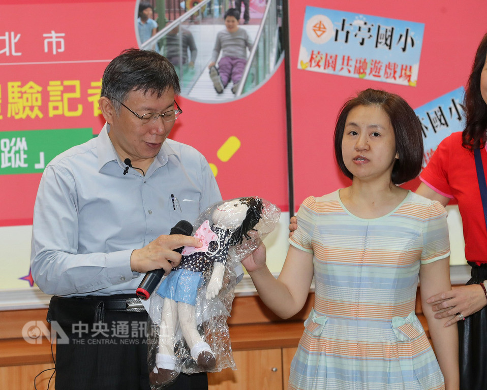 台北市長柯文哲(左)26日在古亭國小出席台北市校園共融式遊戲場體驗記者會,無黨籍台北市議員參選人蔡宜珊(右)突然衝到台前,拿出玩偶和口罩送給柯文哲,針對柯文哲日前「台灣有些女性會不化妝直接上街嚇人」的說法嗆聲,請柯文哲注意發言。中央社記者張皓安攝 107年10月26日