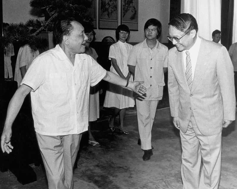 武俠小說泰斗金庸30日去世後,中共官媒大幅報導,但對於金庸過往與已故中共領導人鄧小平的恩仇,報導未見半字。圖為鄧小平(前左)會見金庸(前右)及其家屬。(檔案照片/中新社提供)
