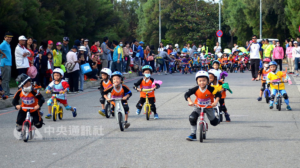 澎湖主委盃直排輪暨滑步車公路賽11日在馬公市觀音亭旁的西瀛勝境附近路段舉行,滑步車計時賽是今年首度增加的賽事,小朋友在賽道上往前衝滑,競爭激烈。中央社 107年11月11日