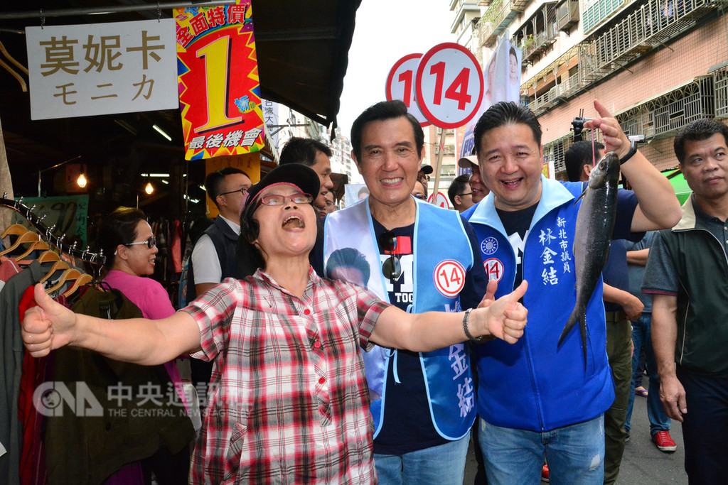 前總統馬英九(中)18日在新北市土城延吉市場,為爭取連任的市議員林金結(右2)輔選,熱情的攤商贈送一尾大魚。中央社記者黃旭昇新北市攝 107年11月18日