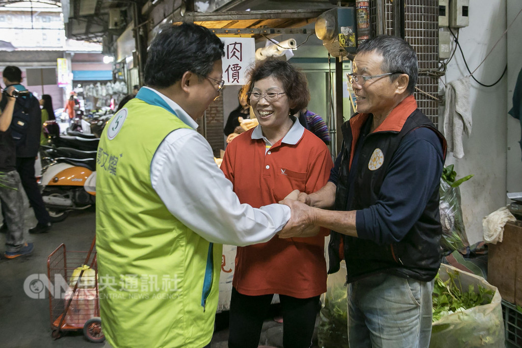 桃園市長鄭文燦(左)18日到市場掃街拜票,沿途有不少民眾紛紛要求合影。他說,桃園一直在進步,沒有藍、綠的差別。中央社記者吳睿騏桃園攝 107年11月18日