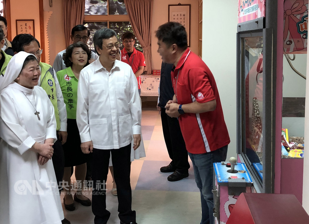 副總統陳建仁(前左2)18日南下嘉義市參訪聖馬爾定醫院附設護理之家,對院內設置長者專屬的娃娃機感到好奇。中央社記者黃國芳攝 107年11月18日