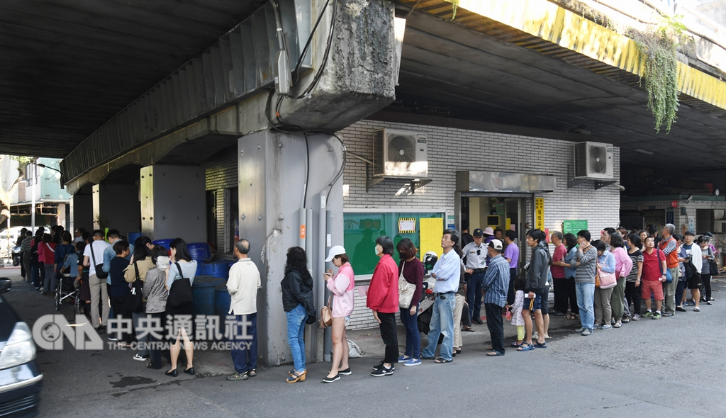 107年地方公職人員選舉及全國性公民投票案第7案至第16案24日登場,2018年公投多達10案,台北市士林區舊佳里投票所前民眾大排長龍,隊伍繞了投票所一圈。中央社記者施宗暉攝 107年11月24日