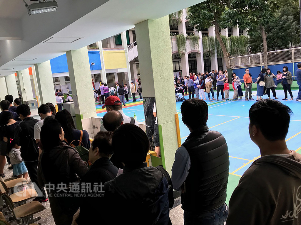 九合一大選暨公投24日投開票,今年公投多達10案,許多投票所都大排長龍,中選會表示,下午4時已經抵達投票所的民眾仍可以投票,屆時隊末也會有警察或選務人員確認。中央社記者陳正杰攝 107年11月24日