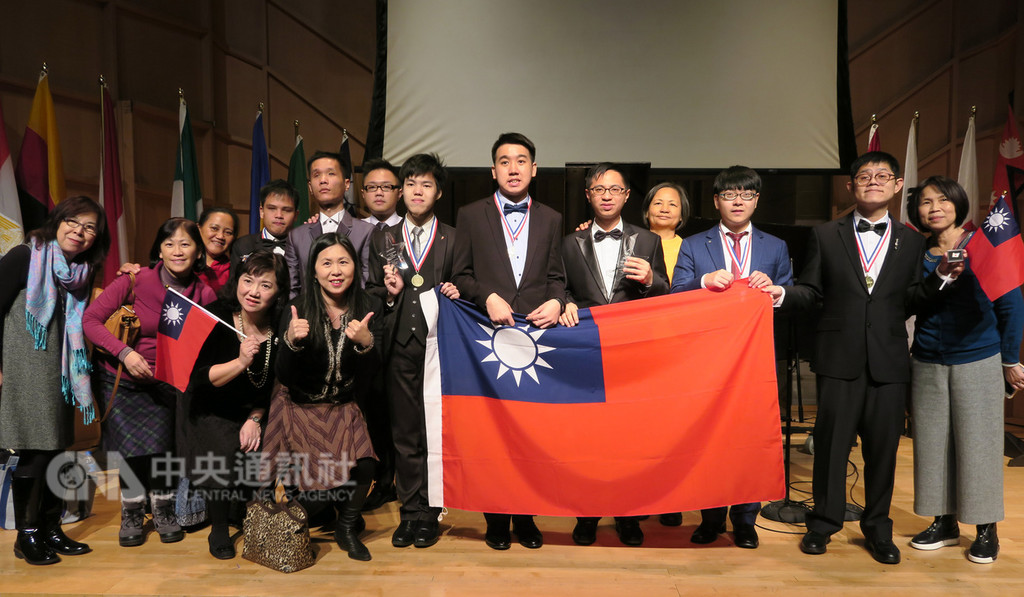 第4屆國際身障鋼琴大賽在紐約舉行總決賽,代表台灣的李尚軒(右5)奪金,王榮堅(右7)獲得銀牌。頒獎典禮後,台灣代表團上台,拉起中華民國國旗合影。中央社記者尹俊傑紐約攝 107年12月4日