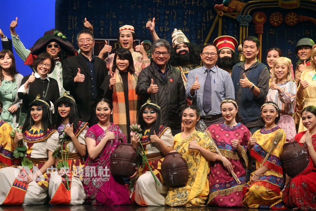 紙風車劇團新作「巫頂看世界」7日在台北城市舞台彩排,多元劇情呈現多國文化,紙風車文教基金會執行長李永豐(後中)與演出者合影。中央社記者鄭傑文攝 107年12月7日