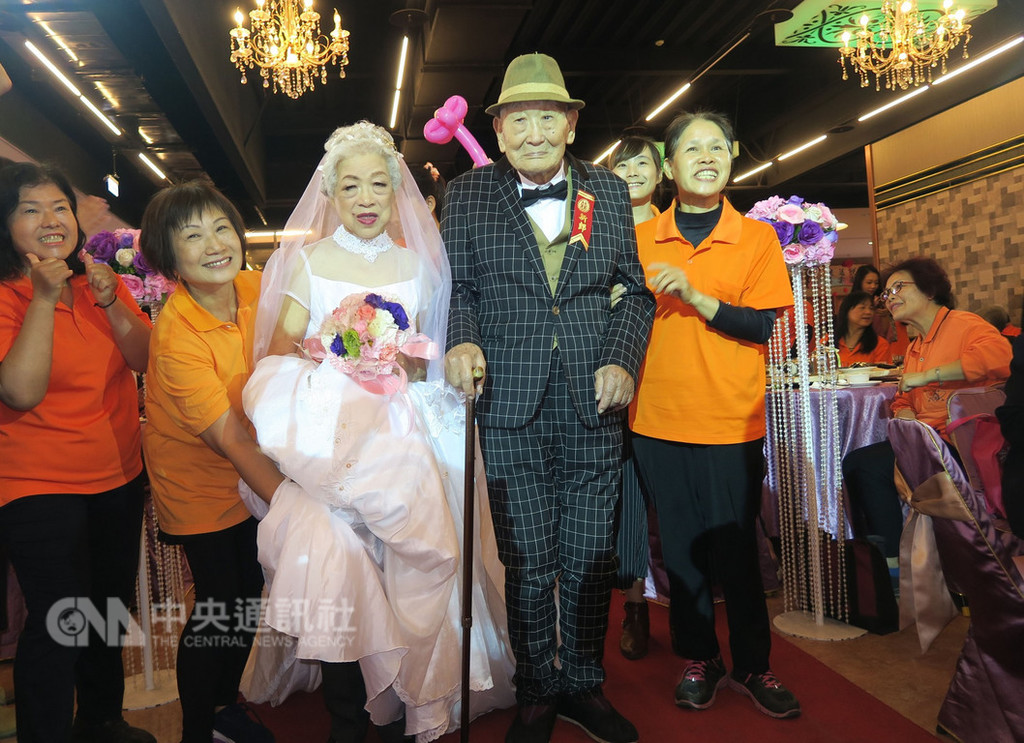 弘道老人福利基金會23日舉辦歲末圍爐餐會及不老婚紗圓夢活動,101歲李福堂爺爺(前右2)與94歲管文英奶奶(左3)夫妻,一圓穿婚紗走紅毯的夢。(弘道老人福利基金會提供)中央社記者蕭博陽彰化縣傳真 107年12月23日
