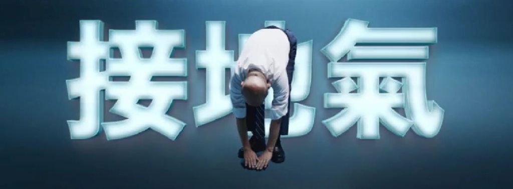 蘇貞昌11日在臉書貼上一段影片,捲起袖子擺出站姿前彎姿勢,雙手觸地,背景亮起「接地氣」燈光,強調要「身段軟,接地氣」。(圖取自www.facebook.com/gogogoeball)