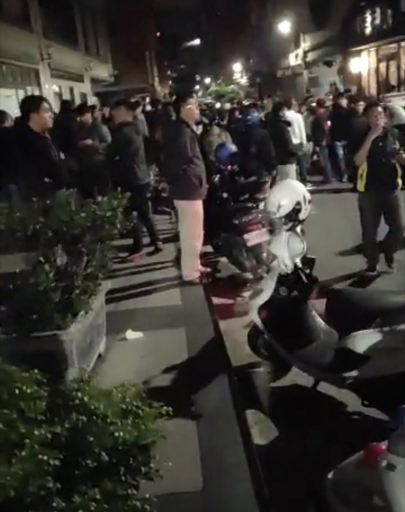 新北市蘆洲區一名男子竟因肉圓未加辣對妻兒家暴,影片曝光後引起民眾怒火,13日晚間大批民眾聚集到男子住家樓下,準備大鍋炒辣椒要等男子回家,警方約晚間11時現身勸離聚集群眾。(翻攝畫面)中央社記者魯鋼駿傳真 108年1月13日