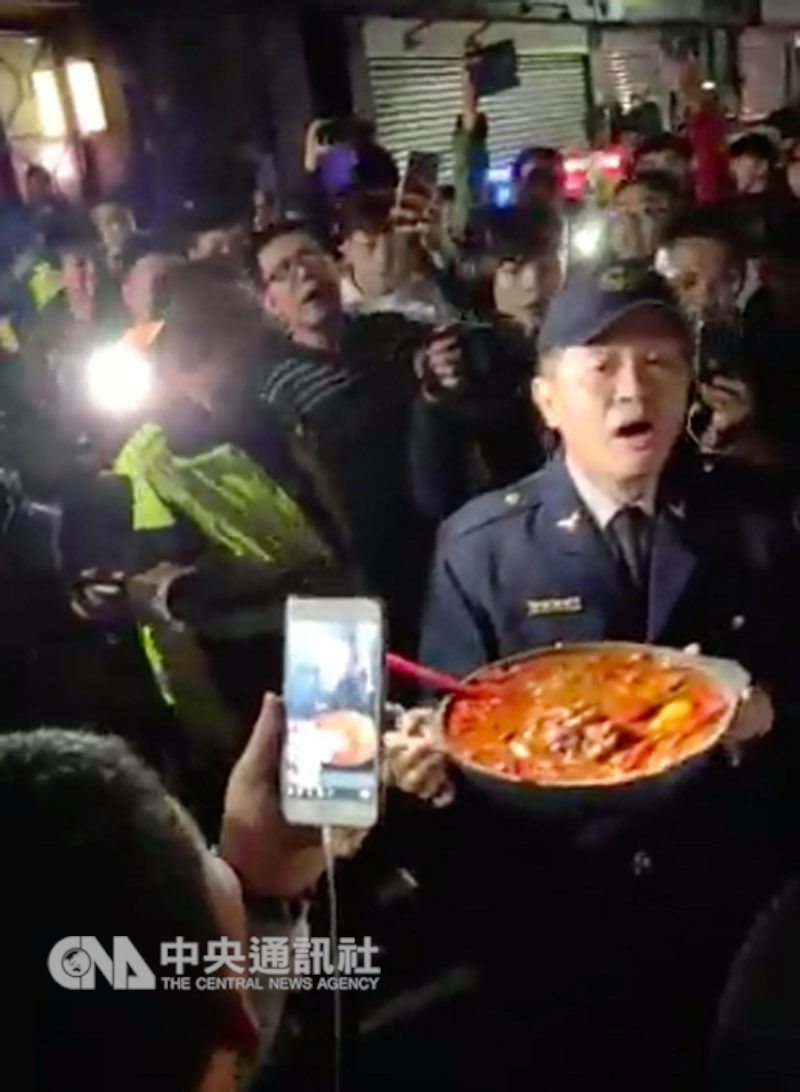 民眾在「爆怨公社」PO出一段影片, 蘆洲一名男子因兒子買的肉圓沒有加辣,對妻兒施暴。13日晚間有民眾聚集男子住家樓下,準備大鍋炒辣椒要等男子回家,警方隨後代表接下炒辣椒,強調不會把炒辣椒丟掉,希望給警方機會處理。(翻攝照片)中央社記者魯鋼駿傳真 108年1月14日