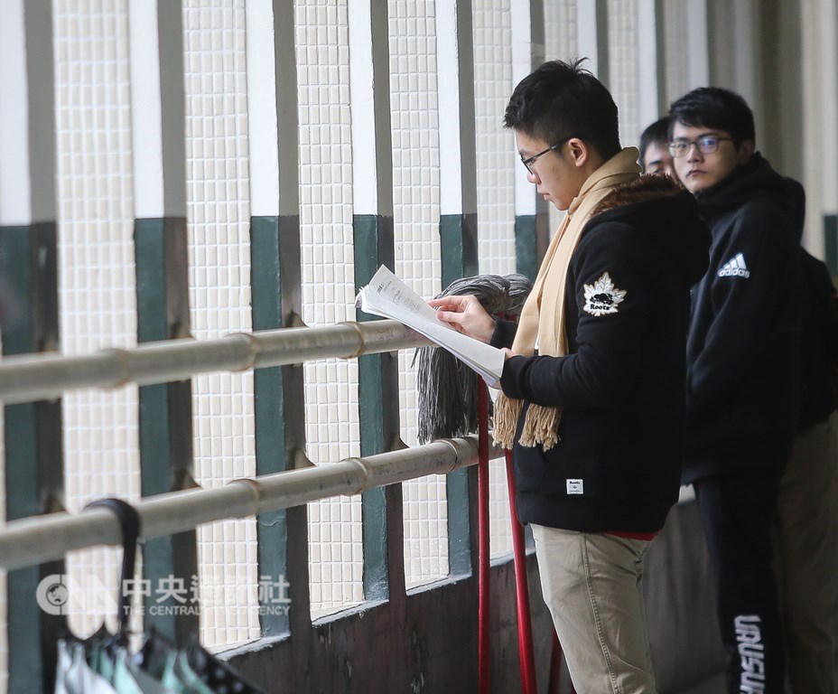 大學學測26日舉行第2天考試,遇上強烈冷氣團來襲,上午考生穿著保暖衣物、戴上圍巾,在教室外拿著教科書及參考書做最後複習。中央社記者謝佳璋攝 108年1月26日