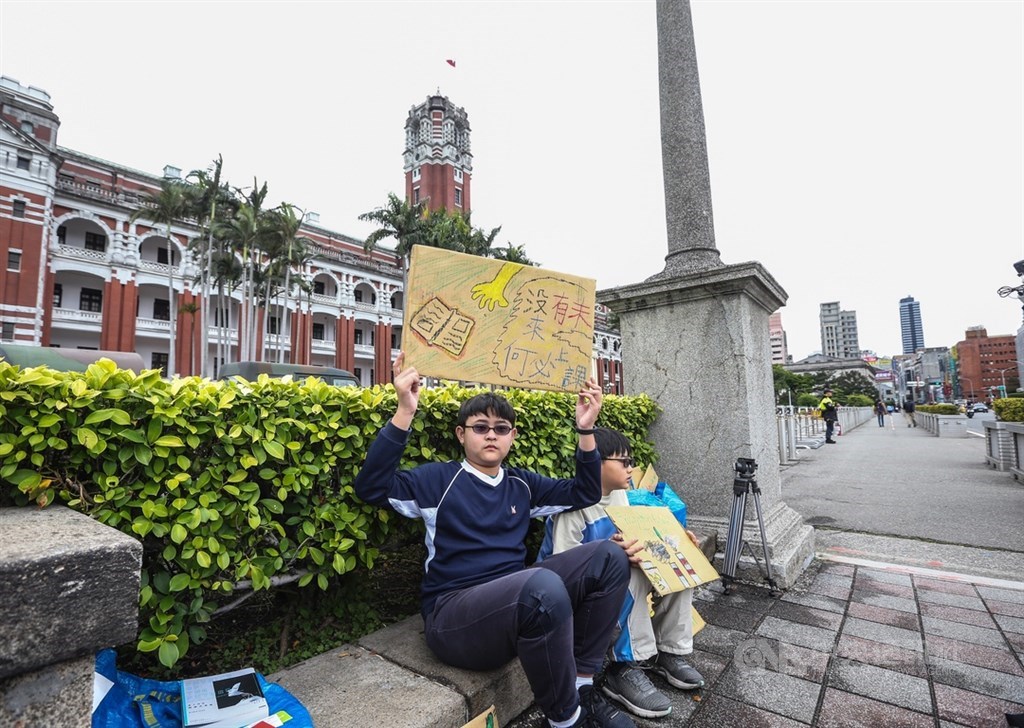 響應「Fridays for future Taiwan」315氣候行動,國小6年級學生楊子慶(左)15日在總統府前靜坐舉牌,希望政府採取行動對抗氣候變遷。中央社記者謝佳璋攝 108年3月15日