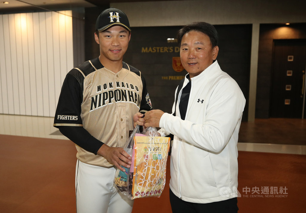 旅日火腿隊野手王柏融(左)休息4場比賽後,16日再次在日職官辦熱身賽亮相;賽前並與老東家Lamigo桃猿隊相見歡,總教練洪一中(右)特別送上台灣零食給王柏融。中央社記者張新偉千葉攝 108年3月16日