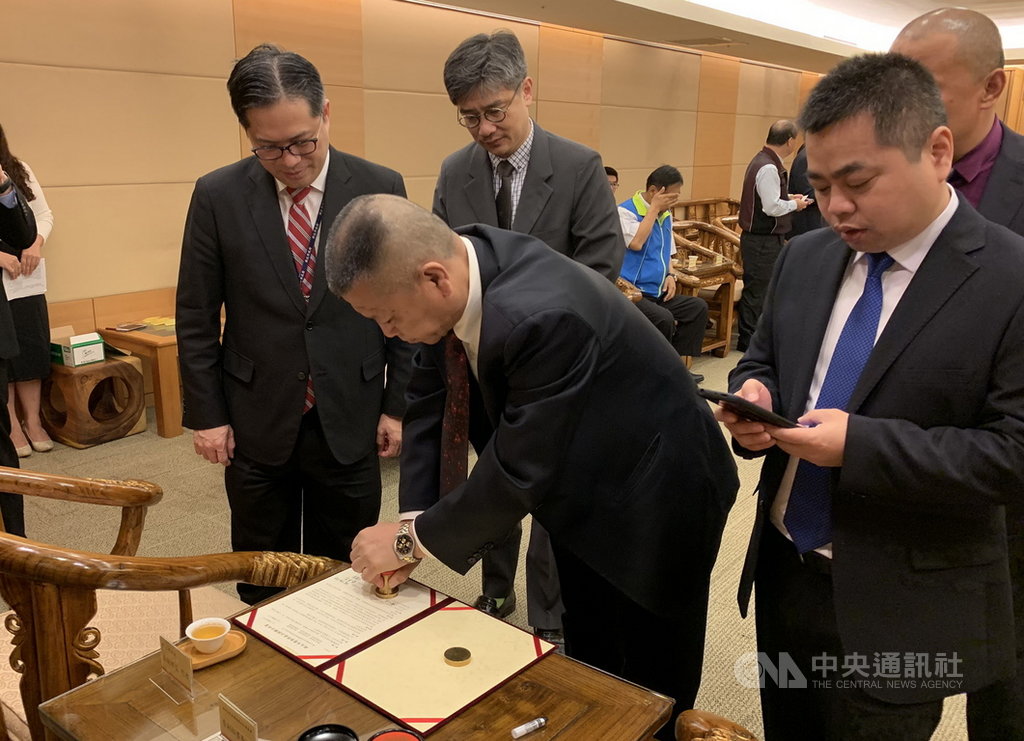 賓大華頓(北京)國際投資公司29日與新北市農會及淡水、金山、萬里、瑞芳、貢寮區漁會簽定農漁特產品採購合約,在新北市副市長吳明機(後左)見證下,由海峽兩岸產業經濟合作委員會副秘書長詹廠慶(前)為採購合約用印。(農業局提供)中央社記者黃旭昇新北傳真 108年3月29日