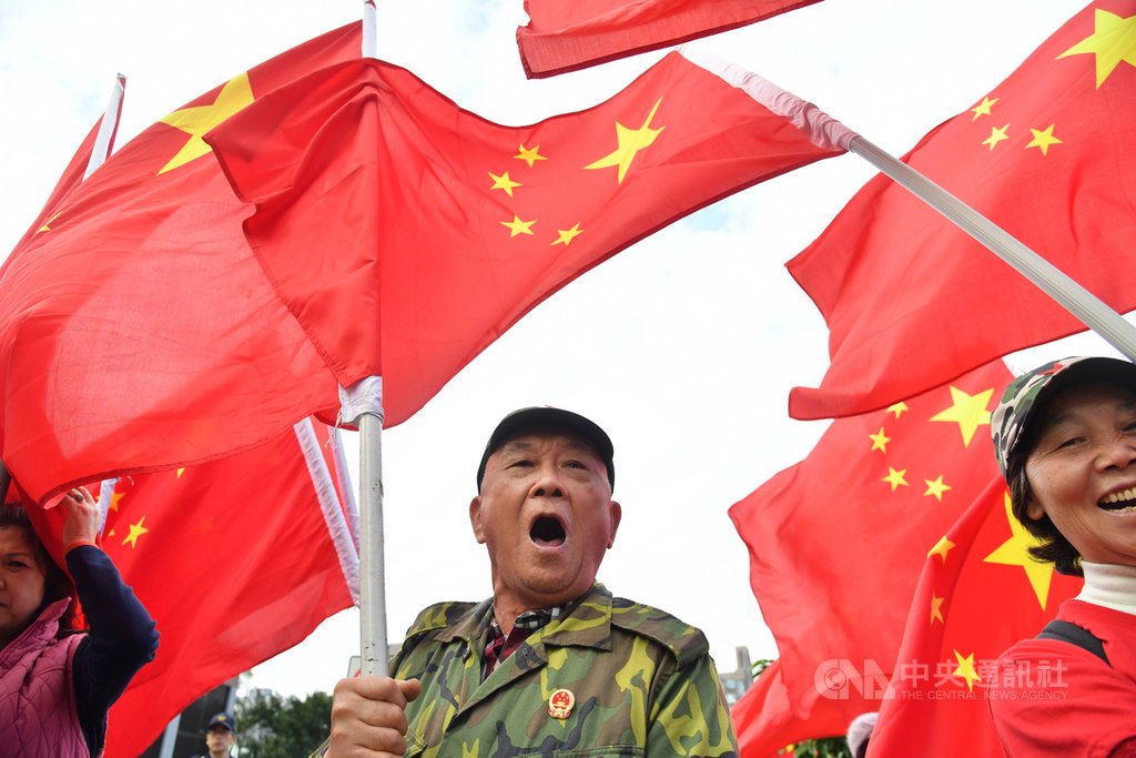 學者吳介民指出,台灣是民主小國,本身還有統獨認同與藍綠分歧,更有一群為數不少的人希望成為「中華人民共和國的人」,在因應「中國因素」上比較辛苦。圖為民眾在台北街頭高舉五星旗。(檔案照片)中央社 108年4月7日