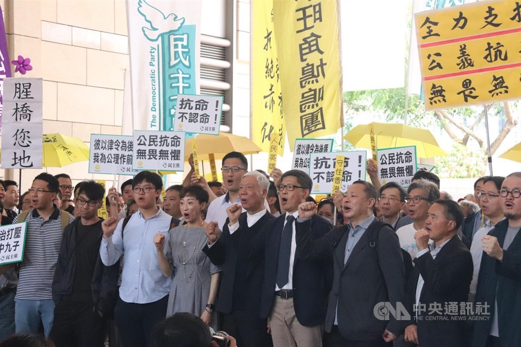 香港「占中」案9日上午法院裁決,「占中」發起人戴耀廷、陳健民和朱耀明被裁定「串謀公眾妨擾」罪名成立。圖為9名被告稍早進入法院前,與支持者齊呼口號要求真普選。中央社記者張偉強香港攝 108年4月9日