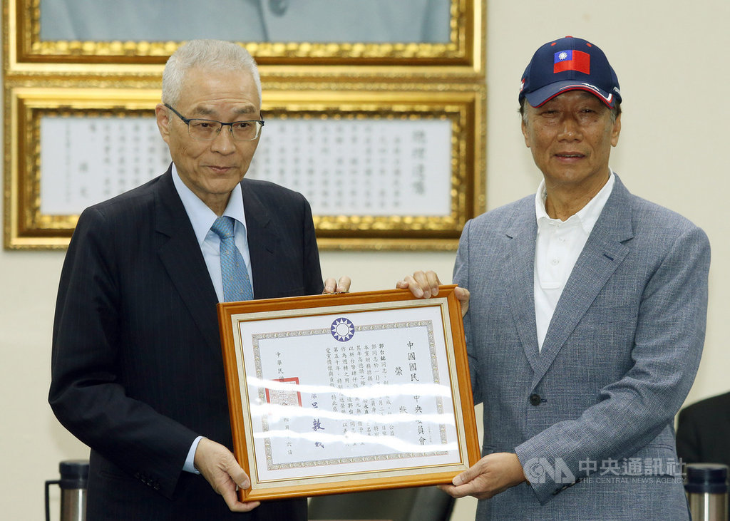 國民黨17日下午舉行中常會,黨主席吳敦義(左)親自頒授鴻海集團董事長郭台銘(右)榮譽狀,吳敦義強調,郭台銘是國民黨黨員,剛好入黨第50年,特別讚揚他愛黨的貢獻。中央社記者郭日曉攝 108年4月17日