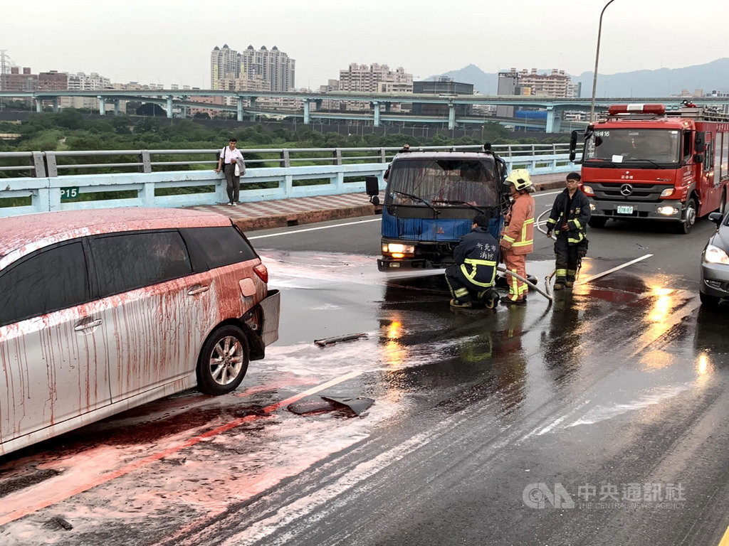 一輛載運豬血的貨車20日行經新北市土城區城林橋時,駕駛疑似精神不濟導致追撞意外,事故現場鮮紅豬血灑滿地,景象嚇人;消防員到場先以水柱沖洗地面,也隨即通知清潔隊前來清理。(翻攝畫面)中央社記者黃旭昇新北市傳真 108年4月20日