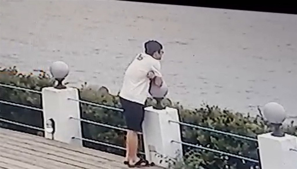 新北市泰山區21日晚間發生兩童命案,吳姓父親涉有重嫌,警方調閱監視畫面追查到淺水灣,畫面中吳男落寞凝視海面,隨後消失在畫面外。(翻攝畫面)中央社記者王鴻國傳真