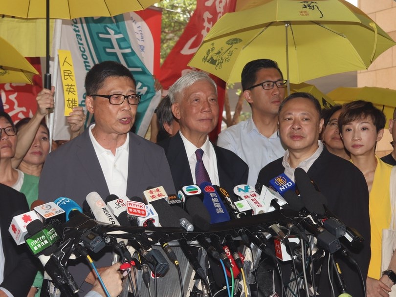 香港法院24日上午宣判占中案各名被告刑期前,9名被告包括「占中三子」陳健民、朱耀明和戴耀廷(圖前排左至右)進入法庭前向媒體發表簡單談話。中央社記者張謙香港攝 108年4月24日