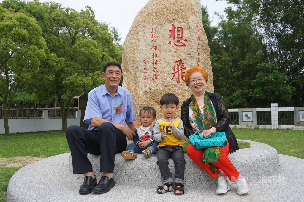 金門縣柏村國小26日舉行60週年校慶,當年學校落成典禮剪綵的學生李孝泉(左)也重返母校,與同是第一屆畢業生的同學胡彩華(右)在「想飛」紀念石留影。中央社記者黃慧敏攝 108年4月26日