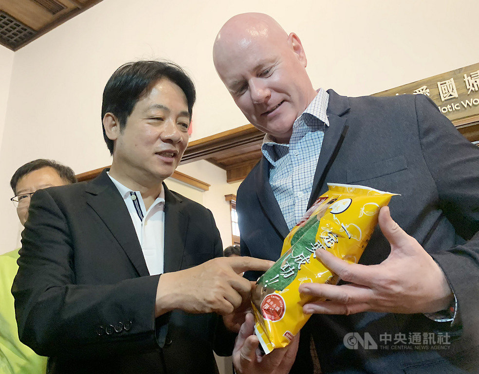 前美國副總統錢尼的副國家安全顧問葉望輝(Stephen Yates)(右)26日和前行政院長賴清德(左)在台南會面,賴清德並向葉望輝介紹芒果口味的台南限定商品「成功洋芋片」。中央社記者張榮祥台南攝 108年4月26日