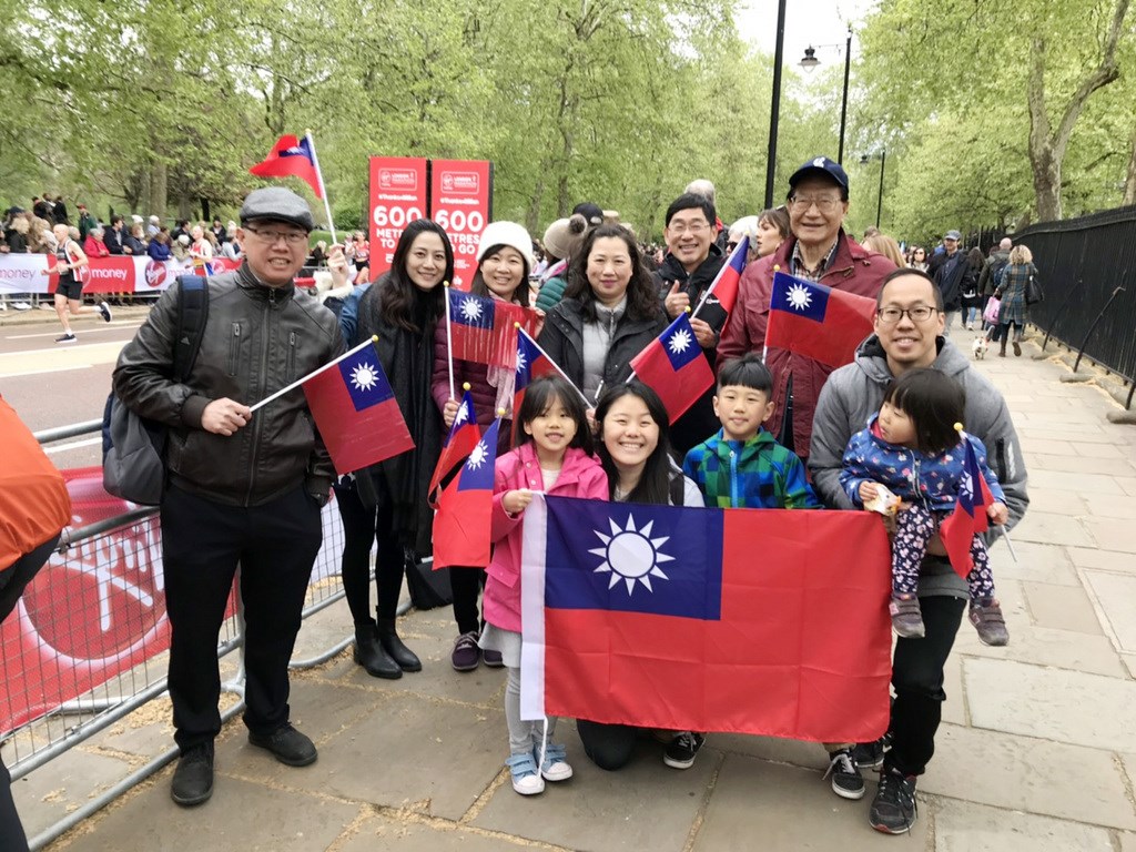 台灣視障跑者洪國展28日參加倫敦馬拉松比賽,僑胞到場加油,揮舞國旗。(駐英代表處提供)中央社記者戴雅真倫敦傳真 108年4月29日