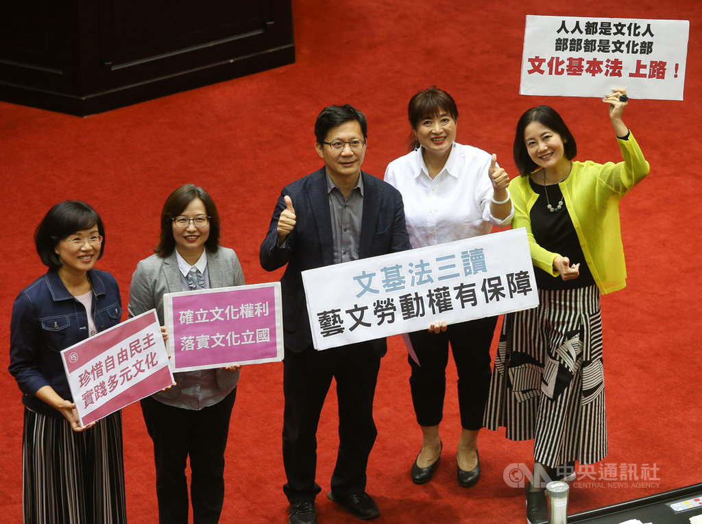立法院院會10日三讀通過文化基本法,強化保障藝術文化工作者勞動權利,條文內容主要採用行政院版本。多名立委在議場中高舉標語、比讚,為文基法順利三讀感到開心。中央社記者謝佳璋攝 108年5月10日