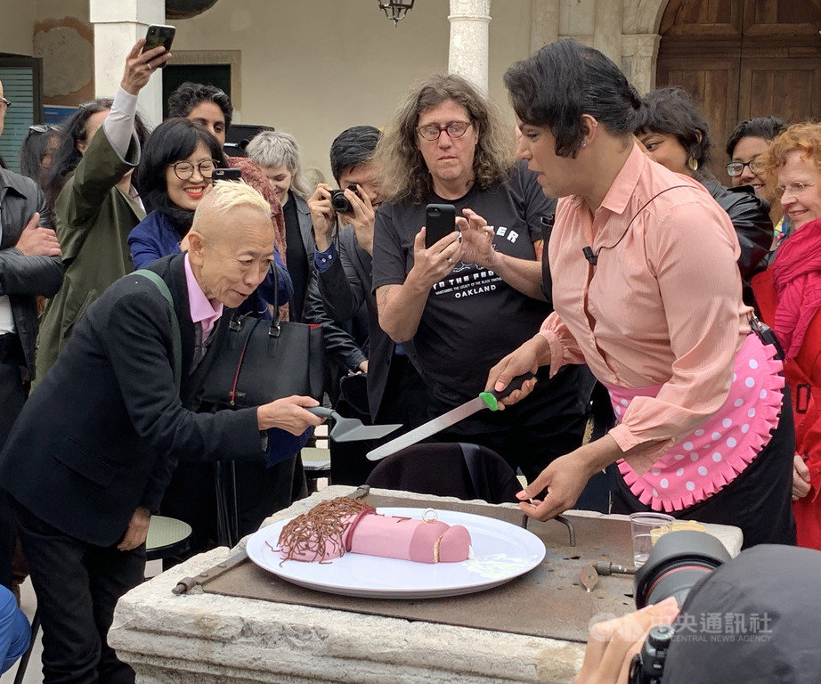 威尼斯雙年展台灣館11日舉辦酷兒主題的公共論壇,演員請藝術家鄭淑麗(左)品嚐陽具造型蛋糕,象徵展覽打破傳統性別思維。中央社記者黃雅詩威尼斯攝,108年5月12日