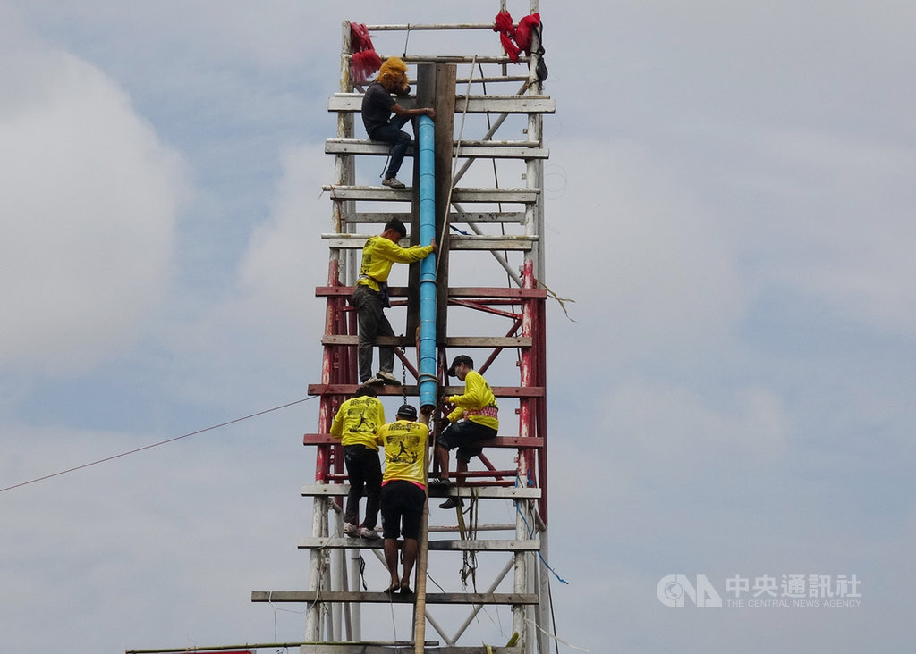 泰國東北部的也梭吞府在12日舉行火箭節比賽,農民組隊發射自製的巨型火箭,代表向老天祈雨,讓農作豐收。圖為參賽農民將火箭綁在發射木架上。中央社記者呂欣憓也梭吞府攝 108年5月13日