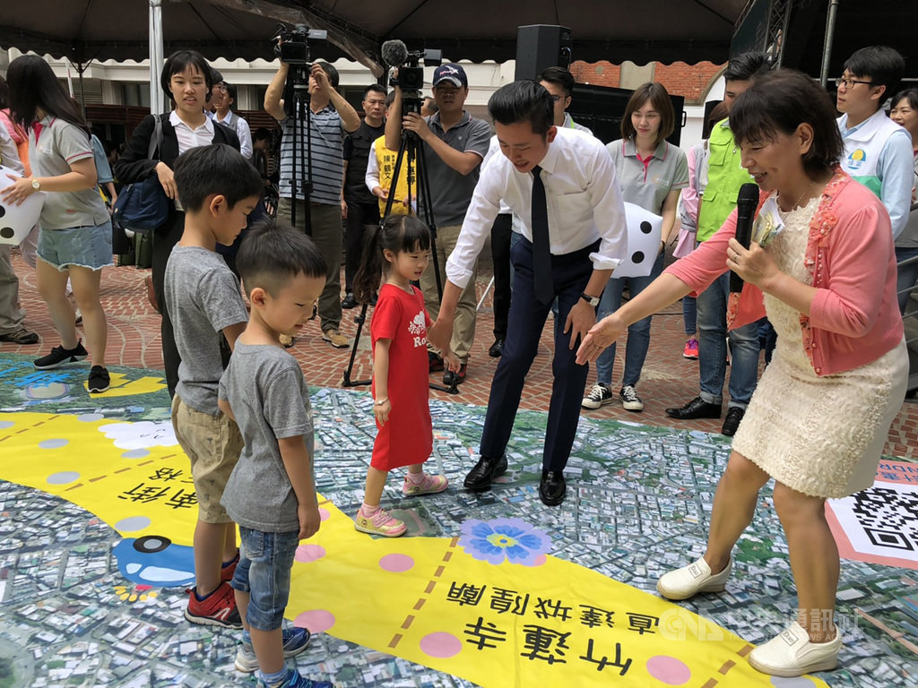新竹市政府逐年進行地形圖修測,並延伸使用地形圖改造成為互動遊戲「步行城市大富翁」及「九宮格立體拼圖」,小朋友透過玩地圖認識新竹市,市長林智堅(前右2)也到場互動。中央社記者郭宣彣攝 108年5月15日