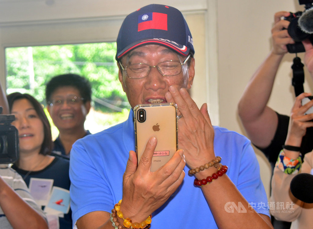 鴻海集團董事長郭台銘(前)16日訪視台東「迦南護理之家」與長輩話家常,看到頭髮全白的90歲蘇姓阿嬤在學習英語,並透過手機與在美國的兒子視訊,郭台銘當場拿出手機與母親視訊,並送上飛吻給母親。中央社記者盧太城台東攝 108年5月16日