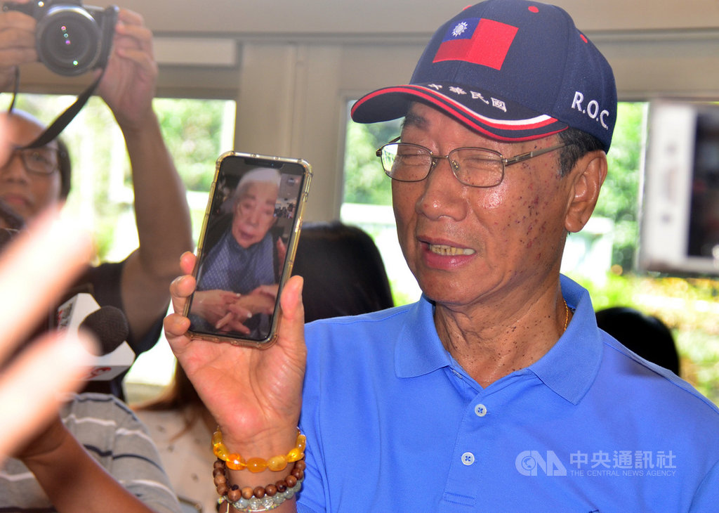 鴻海集團董事長郭台銘(右)16日訪視台東「迦南護理之家」,當場拿出手機與母親視訊,並向母親送上飛吻。手機裡,郭母訝異地問,「你是誰」;郭台銘說,「我是妳兒子郭台銘啦」。中央社記者盧太城台東攝 108年5月16日