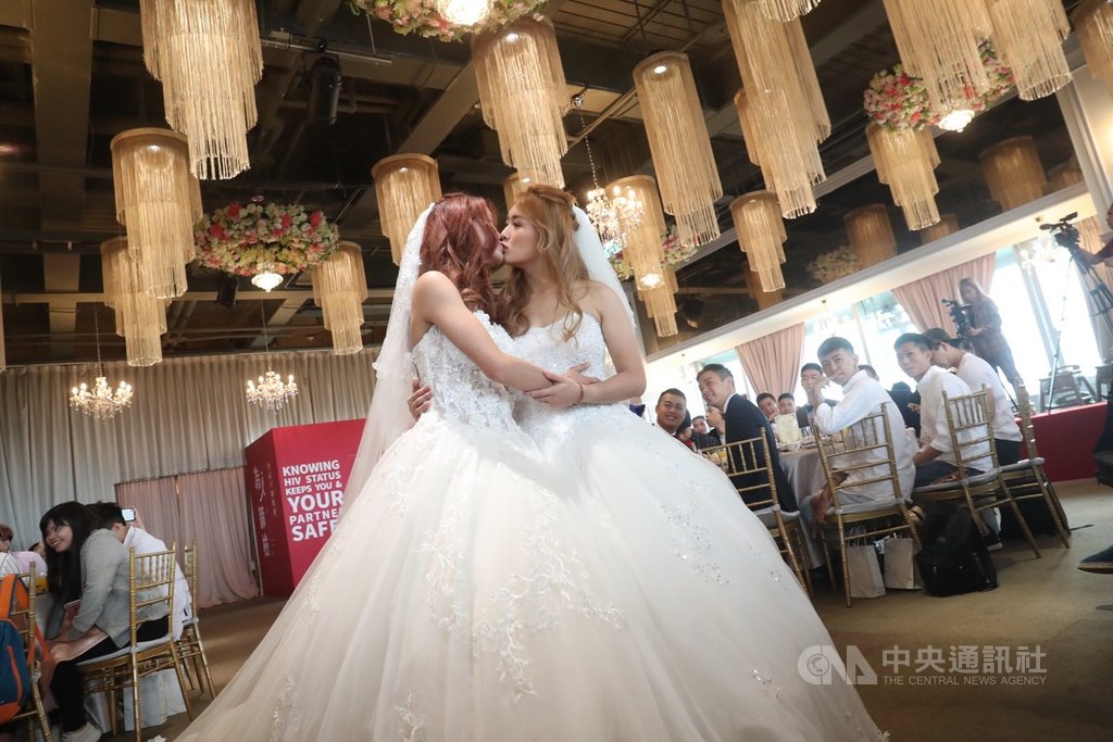 同婚專法過關,首場婚姻平權婚禮18日登場,同性伴侶穿上白紗,在眾人見證下親吻,接受大家的祝福。中央社記者吳家昇攝 108年5月18日