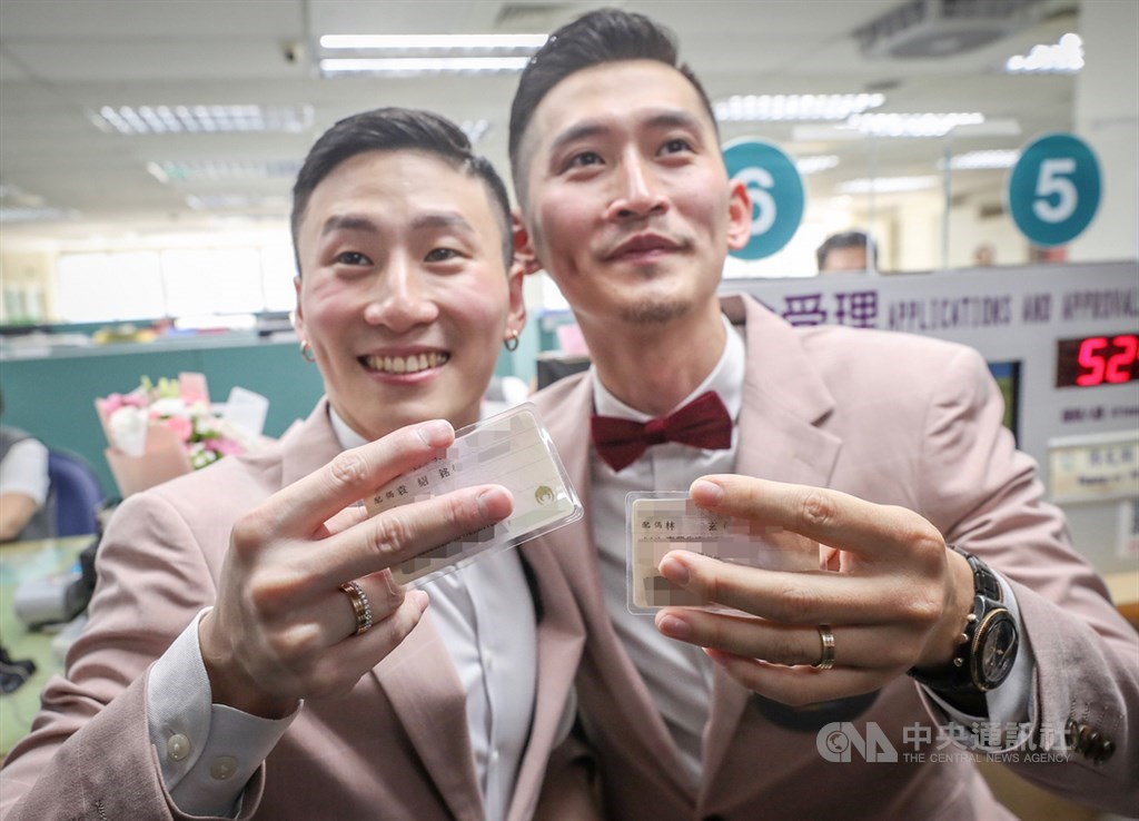 同志伴侶小銘(右)和小玄(左)24日前往台北市信義區戶政事務所辦理結婚登記,兩人更換身份證後,開心展示配偶欄名字。中央社記者裴禛攝 108年5月24日
