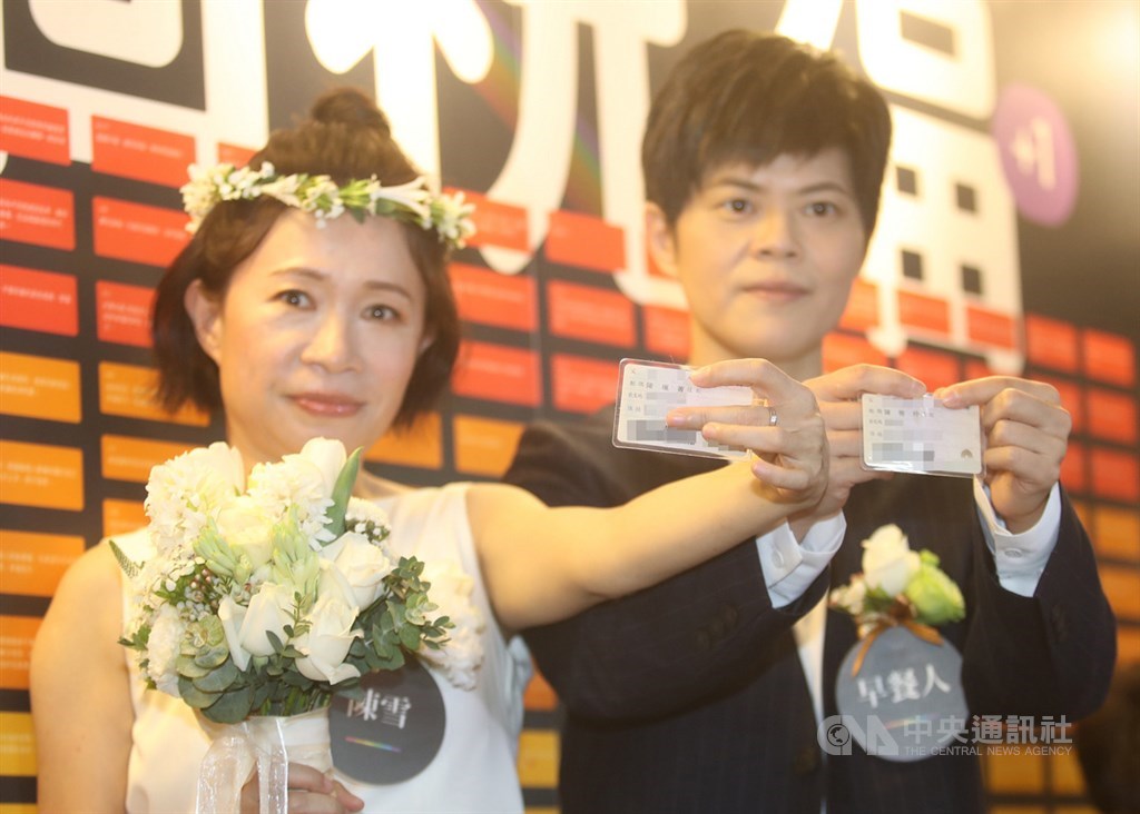 作家陳雪(左)及其伴侶早餐人(右)24日上午到台北市信義區戶政事務所辦理結婚,秀出身分證伴侶欄。中央社記者張新偉攝 108年5月24日