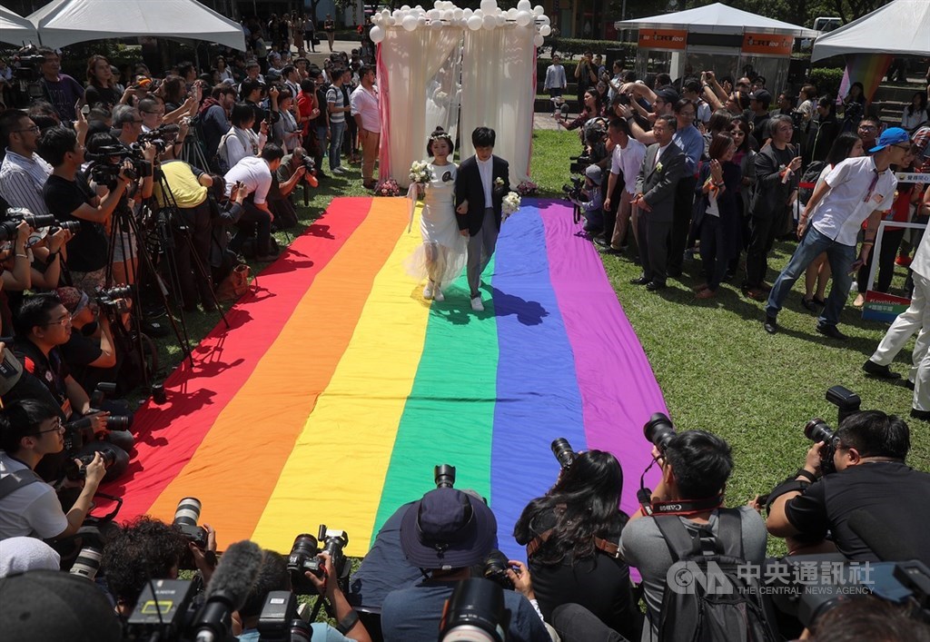 同婚登記24日開跑,同婚團體婚姻平權大平台在戶外舉辦「幸褔起跑線Wedding Party」,同志新人以彩虹旗當作紅毯步入會場,吸引大批媒體到場拍攝。中央社記者裴禛攝 108年5月24日