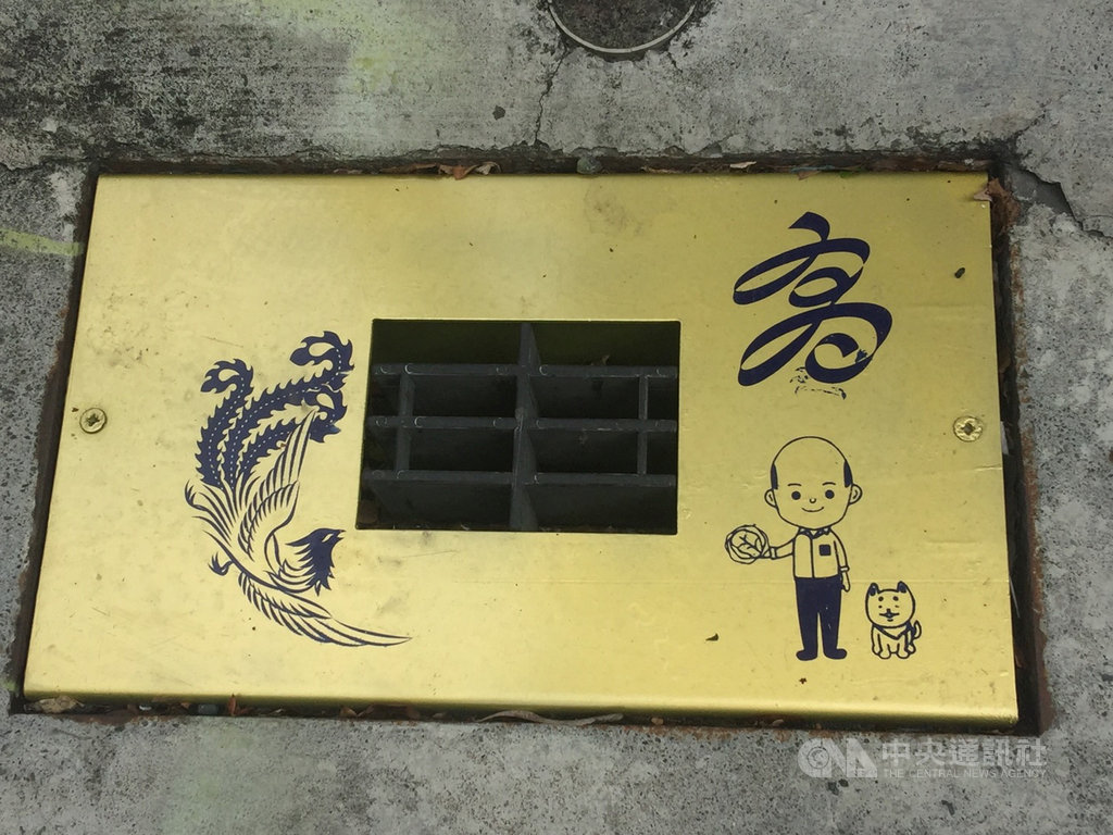 高雄市新興區巷弄出現金色水溝蓋,上印有高雄市長韓國瑜Q版圖像,引發熱議。中央社記者董俊志攝 108年5月27日