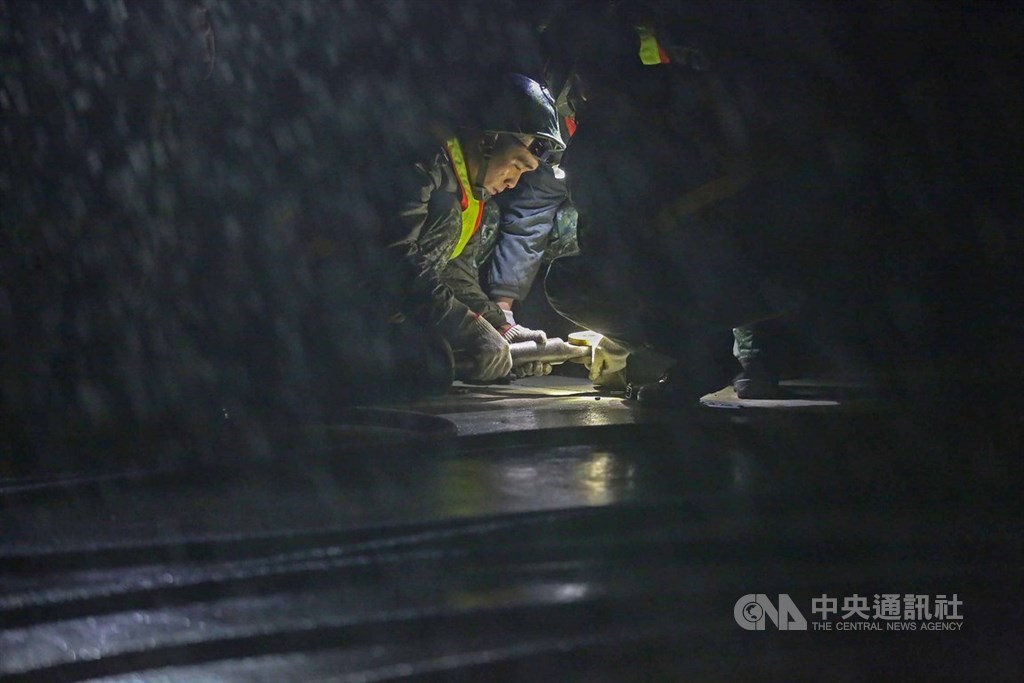 國軍三型戰機28日在彰化戰備道實施操演,由於無法現地演練,官兵只能事前在台中清泉崗機場演練。圖為28日清晨2時實施演練時突然下起滂沱大雨,官兵冒雨執行任務。 中央社記者游凱翔攝 108年5月28日