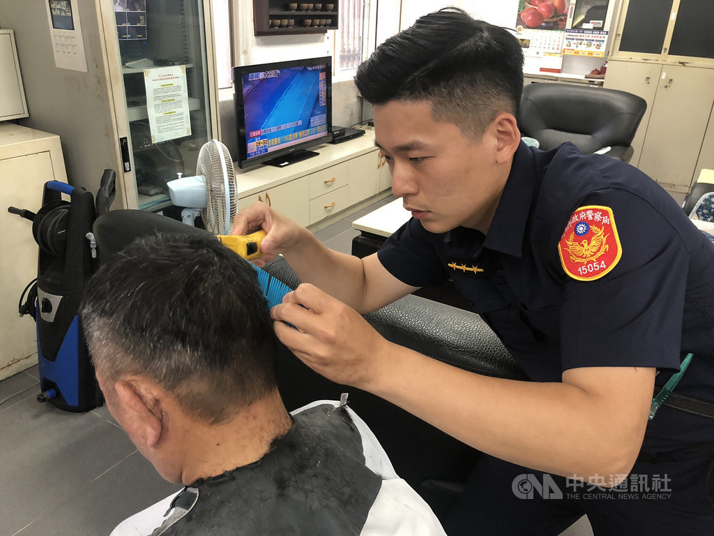 新北市金瓜石地區4日舉辦一場義剪活動,由瑞芳警分局警員黃敏誠(右)操刀,他在從警前曾擔任髮型設計師多年,為弱勢民眾理髮獲得好評。(瑞芳警分局提供)中央社記者王朝鈺傳真 108年6月4日