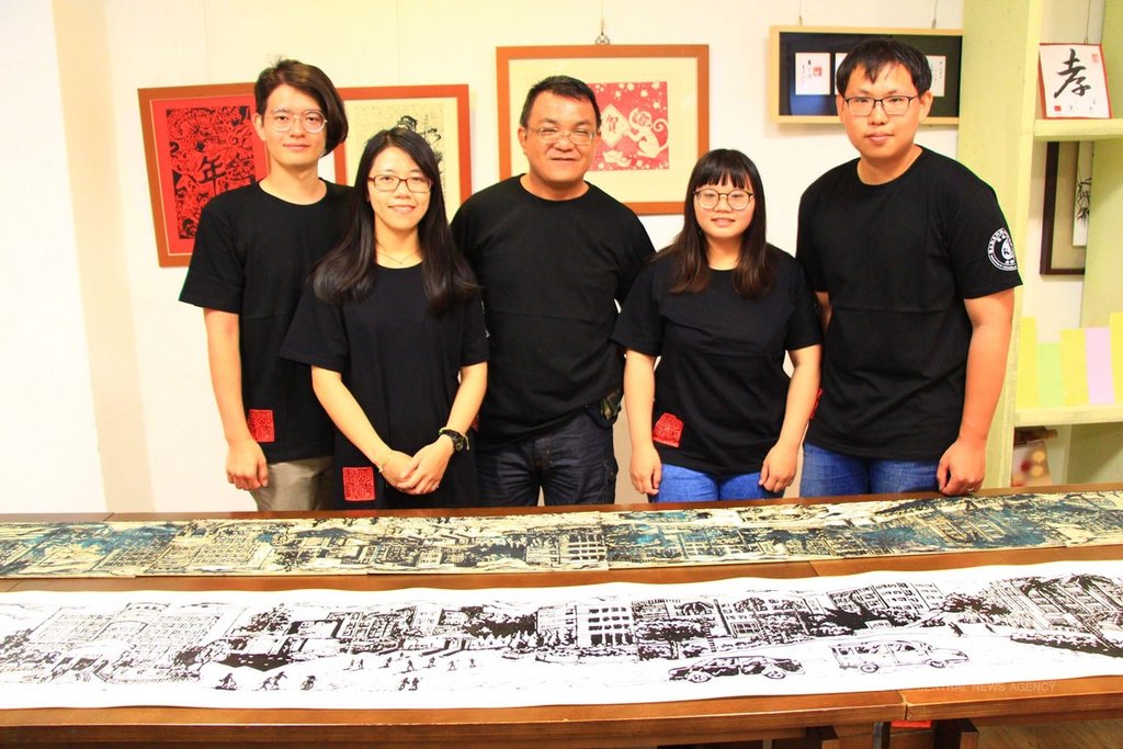 勤益科技大學學生羅啟倫(右)、曾翊晴(右2)、劉任翔(左)、羅以嬛(左2),在指導教師蘇智偉(中)指導下,歷經構圖、繪製、雕刻與拓印等過程,完成長達7公尺長的版畫作品「勤益綿長」。中央社記者蘇木春攝 108年6月4日