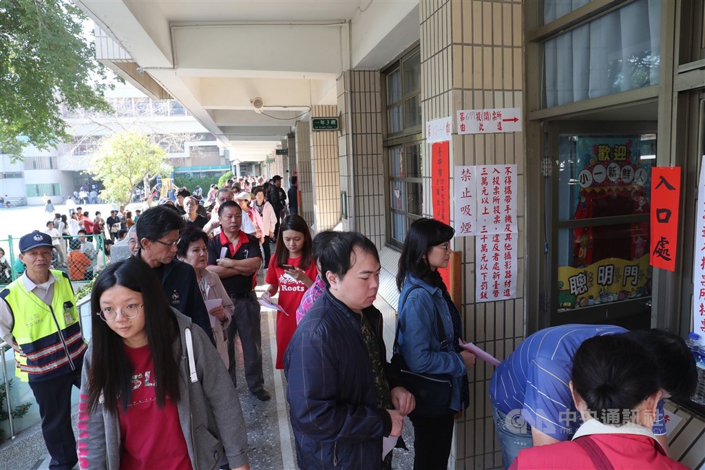 中央選舉委員會副主委陳朝建5日指出,選務執行面的改進方案包括將增設1500個投票所,並要求每個投票場所的空間要在50平方米以上。圖為2018年九合一選舉民眾排隊等待投票。(中央社檔案照片)