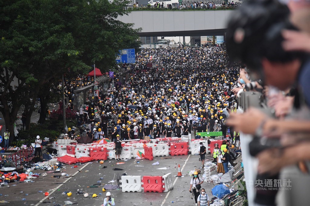 香港12日有大批民眾聚集在立法會外並占領金鐘主要幹道抗議逃犯條例修訂;下午近4時,香港警方施放催淚彈驅離部分民眾,場面一度混亂,地面上散落著雨傘、安全帽等物品。中央社記者王飛華攝 108年6月12日