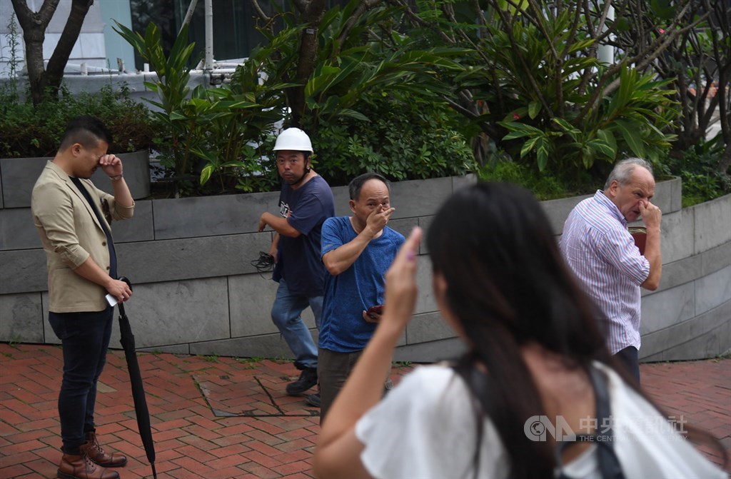 香港警方12日下午近4時施放催淚彈欲驅離聚集在立法會外並占領金鐘主要幹道的抗議民眾,讓周邊未戴護具的民眾,被薰得十分難受,紛紛捏鼻子揉眼睛。中央社記者王飛華攝 108年6月12日