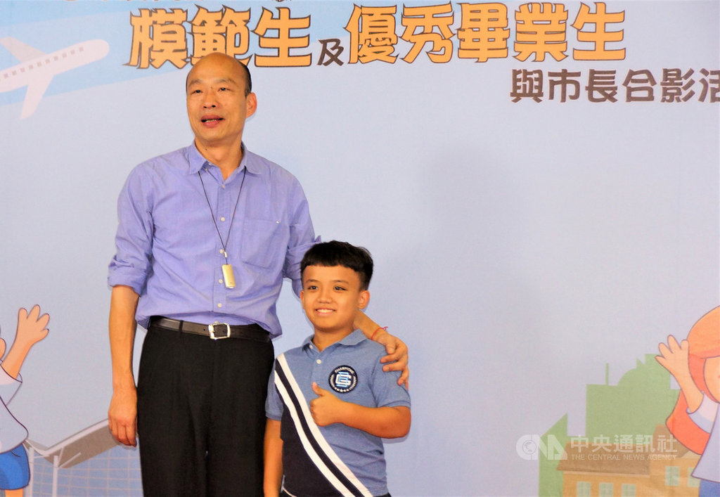高雄市長韓國瑜(左)13日下午到美濃國中參加模範生及優秀畢業生與市長合影活動,和身高僅120公分的內門國小特教班學生柯崇彭(右)合影,肯定他積極向學,熱心助人。中央社記者程啟峰高雄攝 108年6月13日