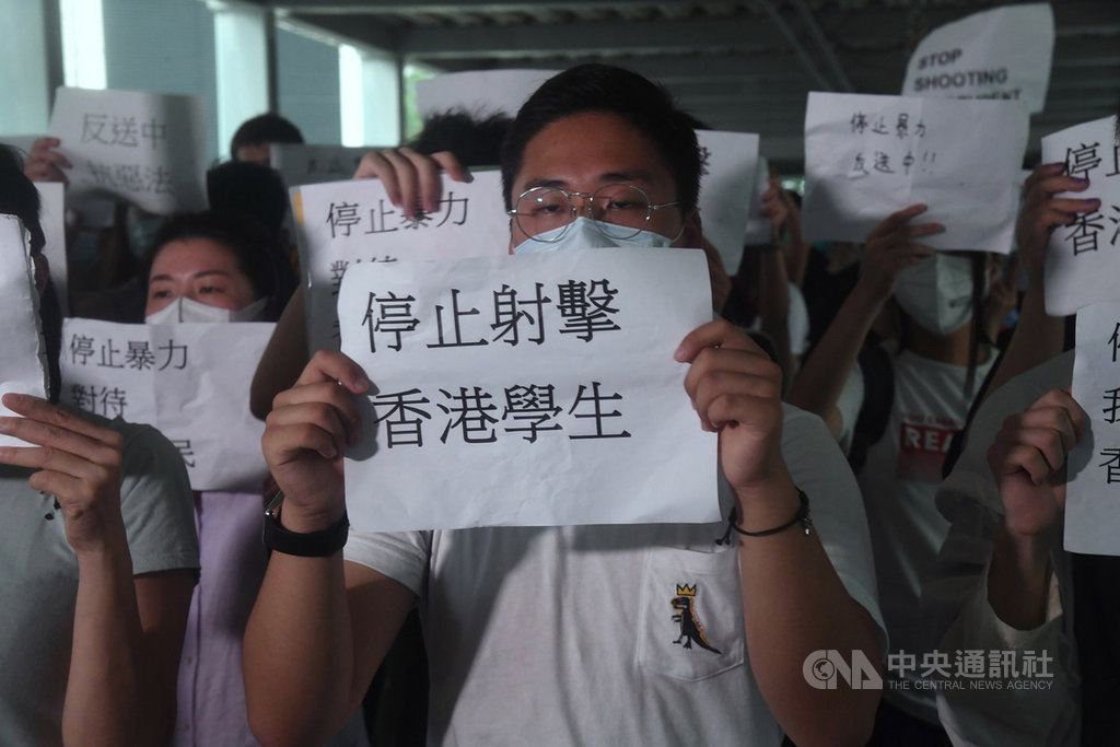 香港12日再度發起大規模反送中活動,當地警方強力驅散人群後,13日仍有許多民眾在立法會外周邊舉著標語,呼籲警方勿射擊學生。中央社記者王飛華攝 108年6月13日