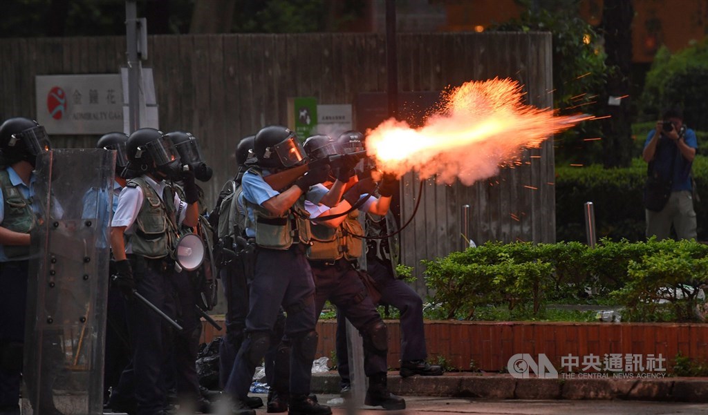 香港12日因為逃犯條例修訂草案二讀,大量民眾聚集抗議,警方午後作法轉趨強硬,下午4時後陸續向民眾發射催淚彈,抗議群眾則往周邊區域移動。中央社記者王飛華攝 108年6月12日